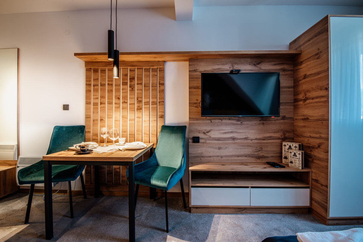 Modern wood dining table with green upholstered chairs